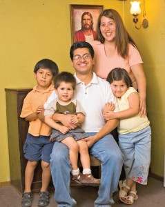 Mormon Family posing in front of painting of Jesus Christ.