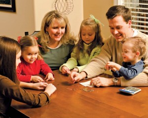 Mormon Family playing games around the kitchen table.